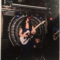 a woman playing a guitar in front of a crowd