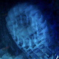 a close up of a face in a glass of water